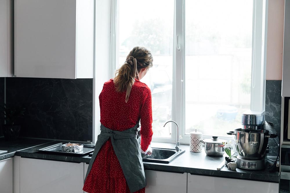 a person using the kitchen sink a person using the kitchen sink