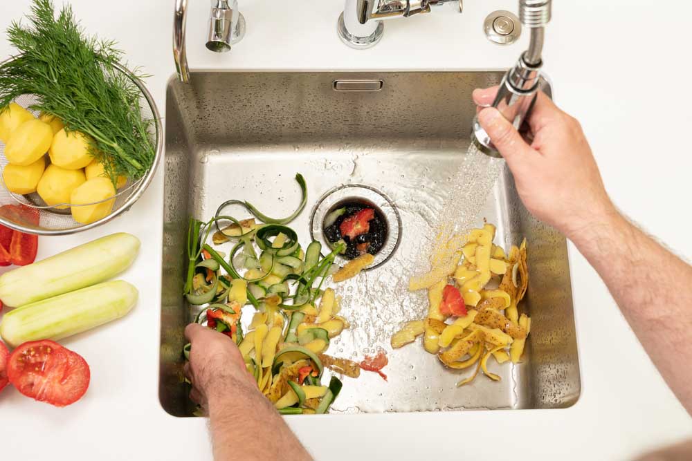 a person using their kitchen garbage disposal