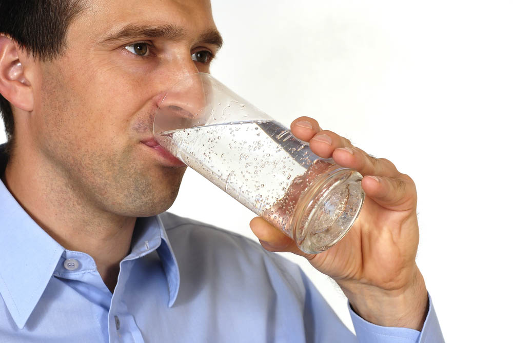 person drinking water from a glass